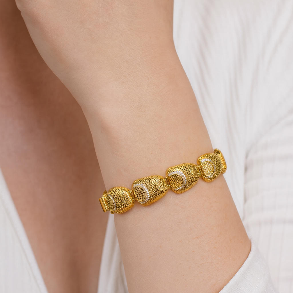 Gold bracelet on a person's wrist with a neutral background