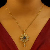 Gold necklace with a diamond pendant on a person wearing a red garment.