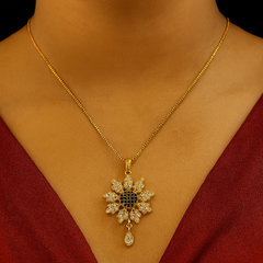 Gold necklace with a diamond pendant on a person wearing a red garment.