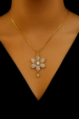 Gold necklace with a floral pendant on a black background