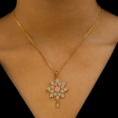 Gold necklace with a star-shaped pendant on a black background