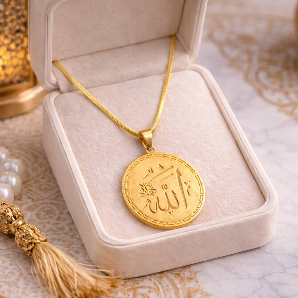 Gold necklace with a pendant in an open jewelry box on a textured surface.