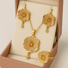 Gold floral jewelry set with necklace, earrings, and ring in a box